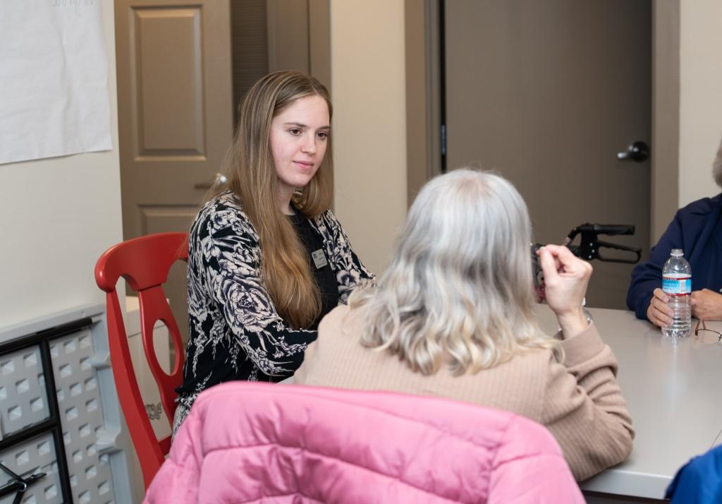 A student speaks with a resident of an assisted living facility