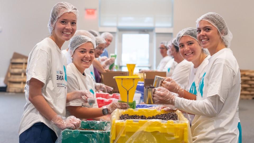 A group of students pack rice and beans for the Meals for Maine event